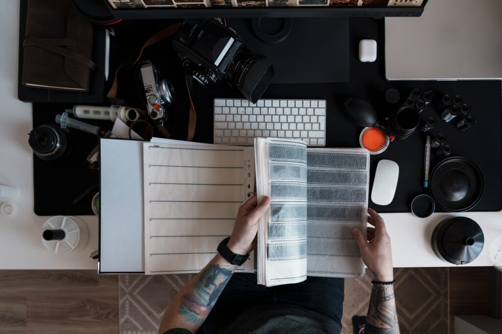 Photographer reviewing negatives at a modern desk setup